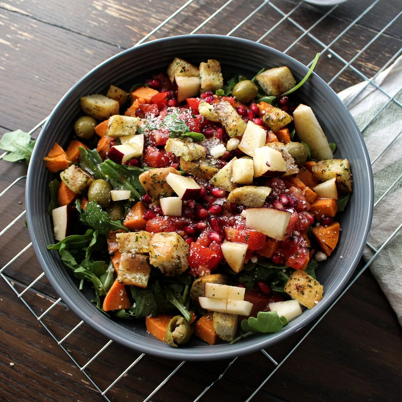 Bát salad rau củ và trái cây tươi đặt trên bàn gỗ tối